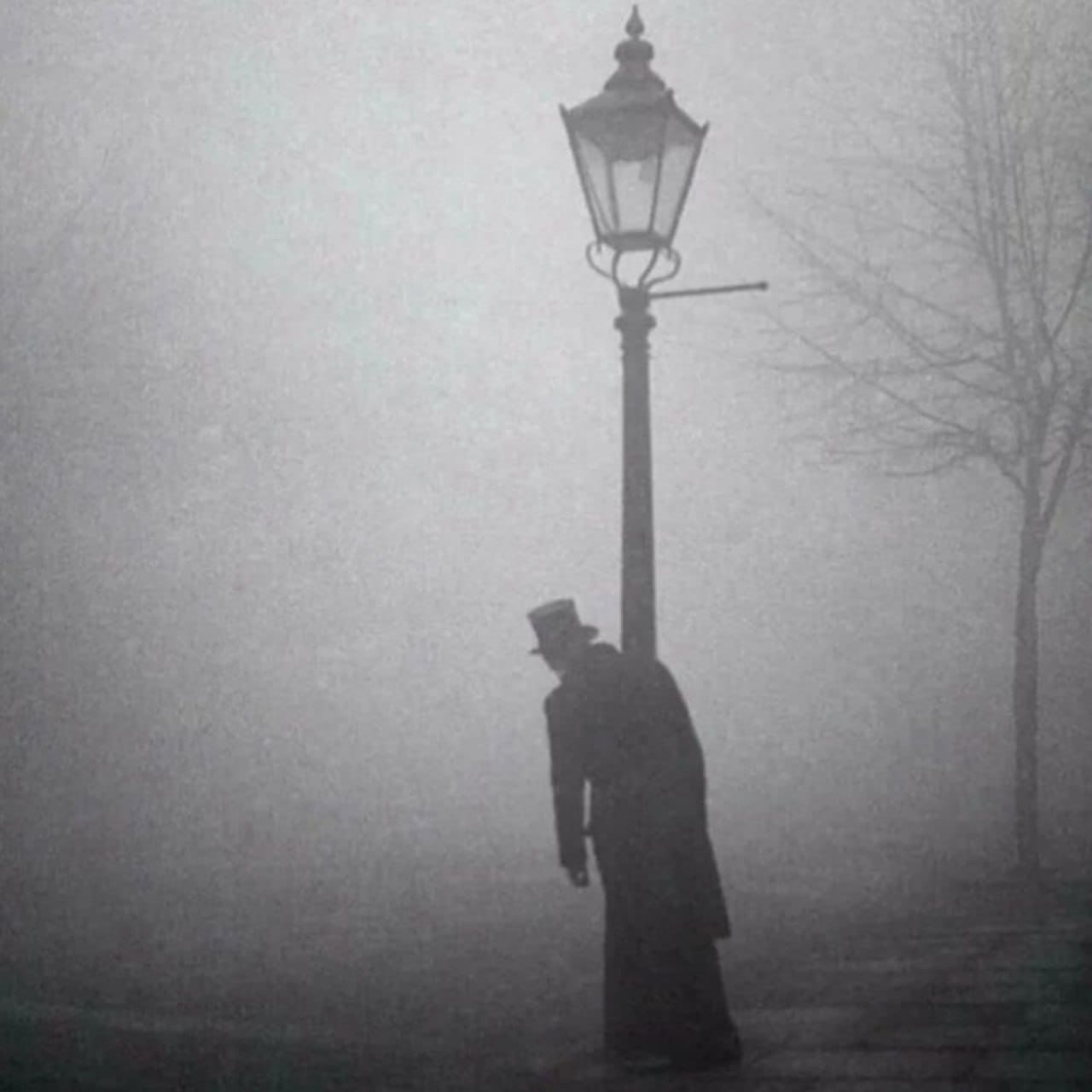 A drunkard leaning on a lamp post at night in London, 1934