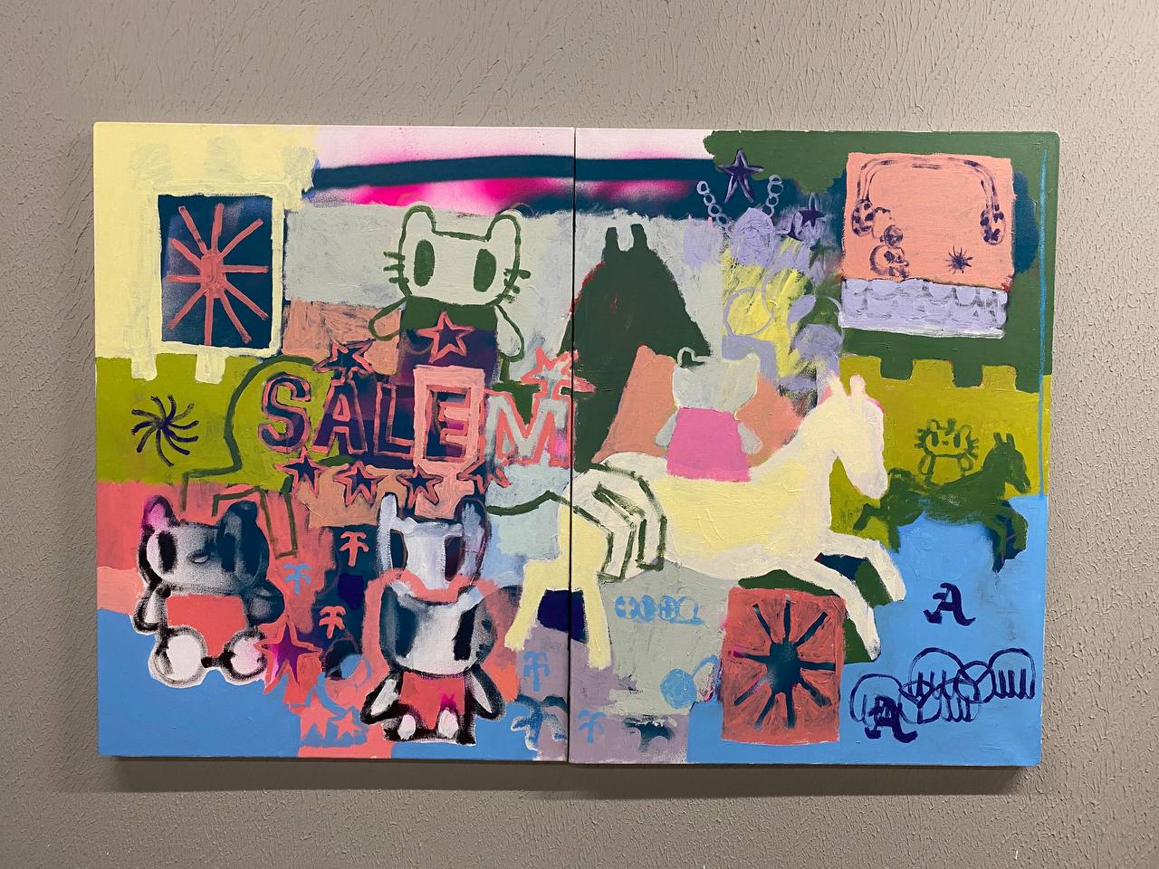 Peinture sur deux toiles accrochée à un mur gris : aplats de couleur, chevaux blanc et vert, chats stylisés, étoiles, soleils et le mot SALEM.