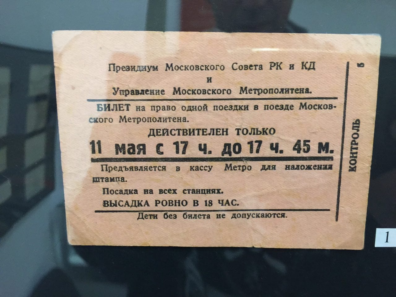Billet en papier rosé du métro de Moscou, en caractères noirs : valable le 11 mai de 17 h à 17 h 45, descente à 18 h précises. Objet exposé sous verre.
