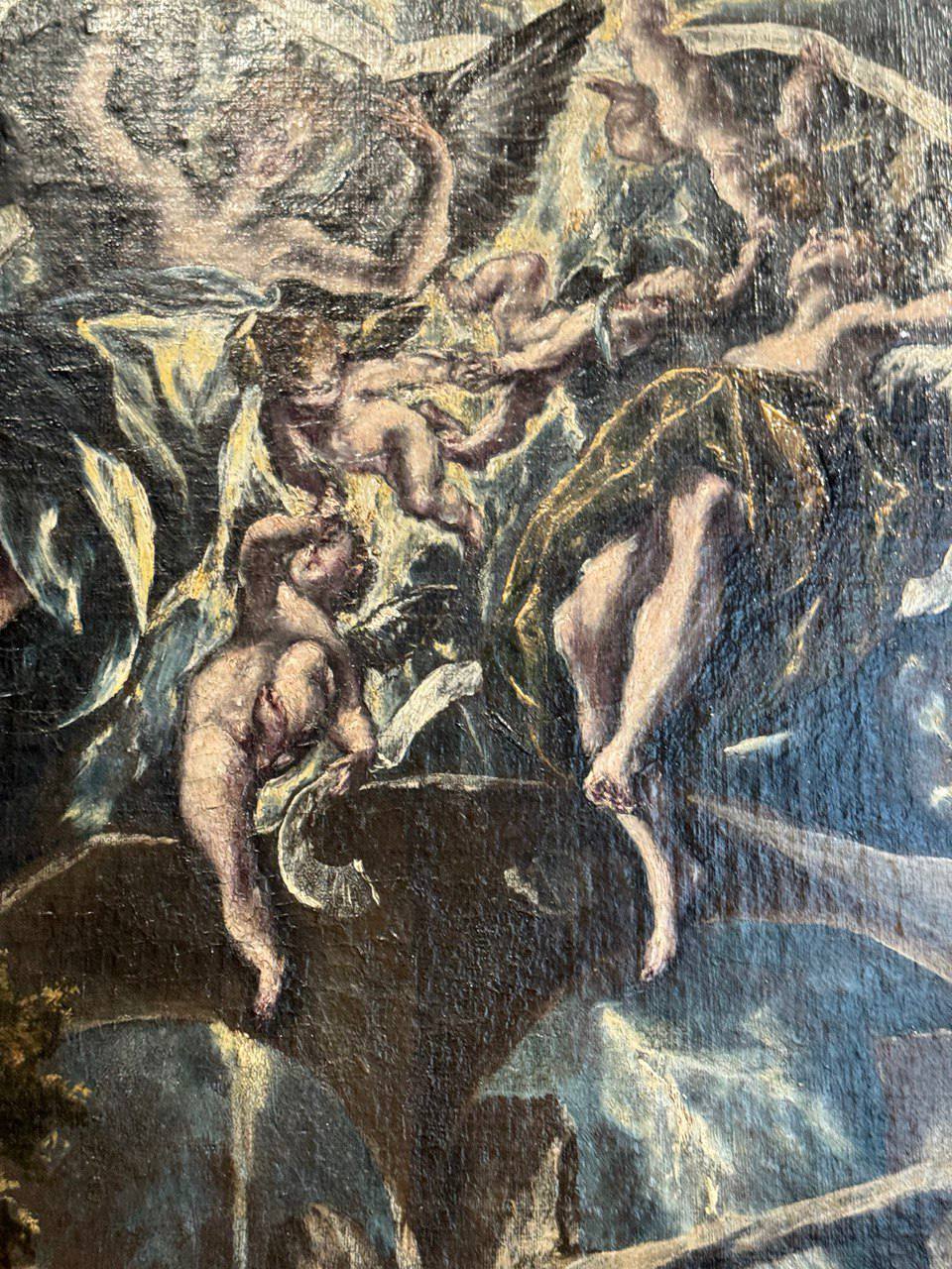 Détail d’une huile ancienne : anges ailés et enfants nus dans des drapés flottent dans un ciel sombre au-dessus d’une saillie rocheuse. La surface peinte est craquelée.