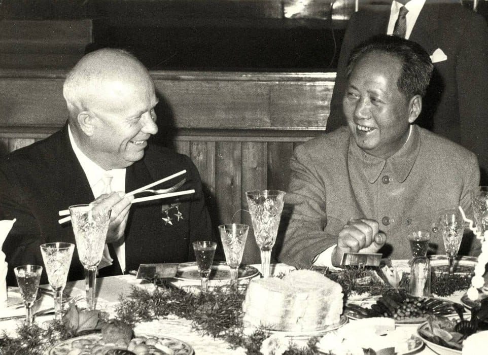 Nikita Sergueïevitch Khrouchtchev, baguettes chinoises en main, à table avec Mao Zedong lors de la visite officielle soviétique à Pékin en 1959