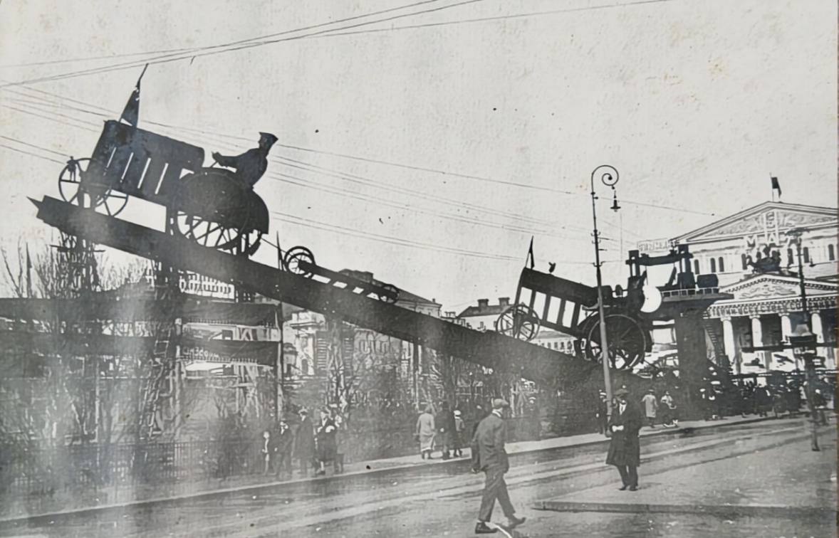 I was leafing through an album of photographs of 1930s Moscow and came upon a picture of Theatre Square decked out for May Day with outline models of tractors and ploughs
