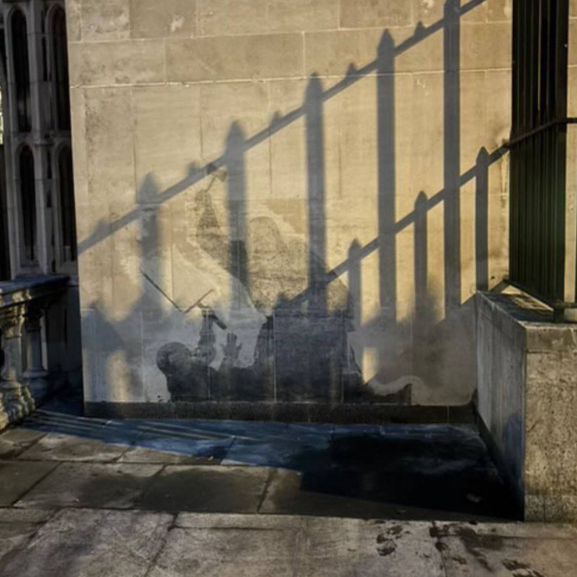 Banksy's graffiti has been scrubbed off, but the stain in the shape of a ferocious judge looks even more epic