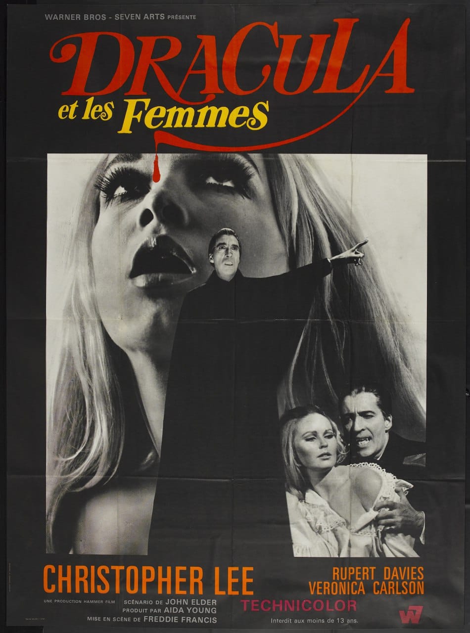 Affiche en noir et blanc : grand visage de femme blonde, homme en cape noire le bras tendu, couple en bas à droite. Titre rouge avec goutte de sang, noms des acteurs.