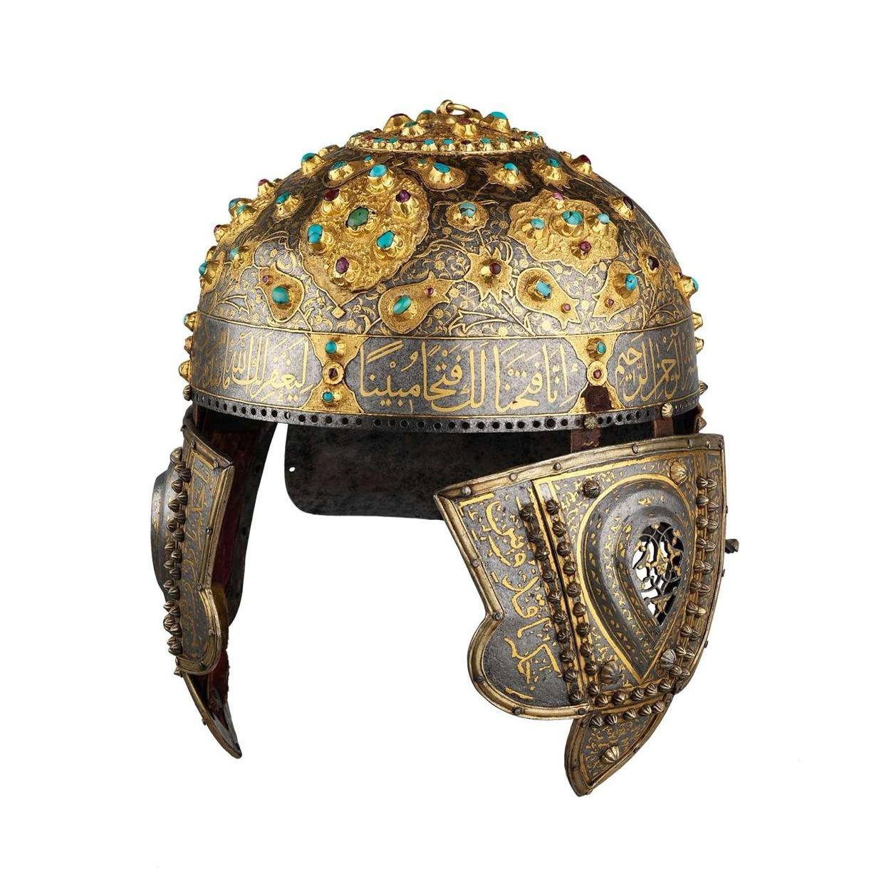 Casque en acier à calotte bombée ornée de rosaces d'or serties de turquoises et de rubis. Une inscription arabe dorée court sur le bord; des protège-joues sont visibles.