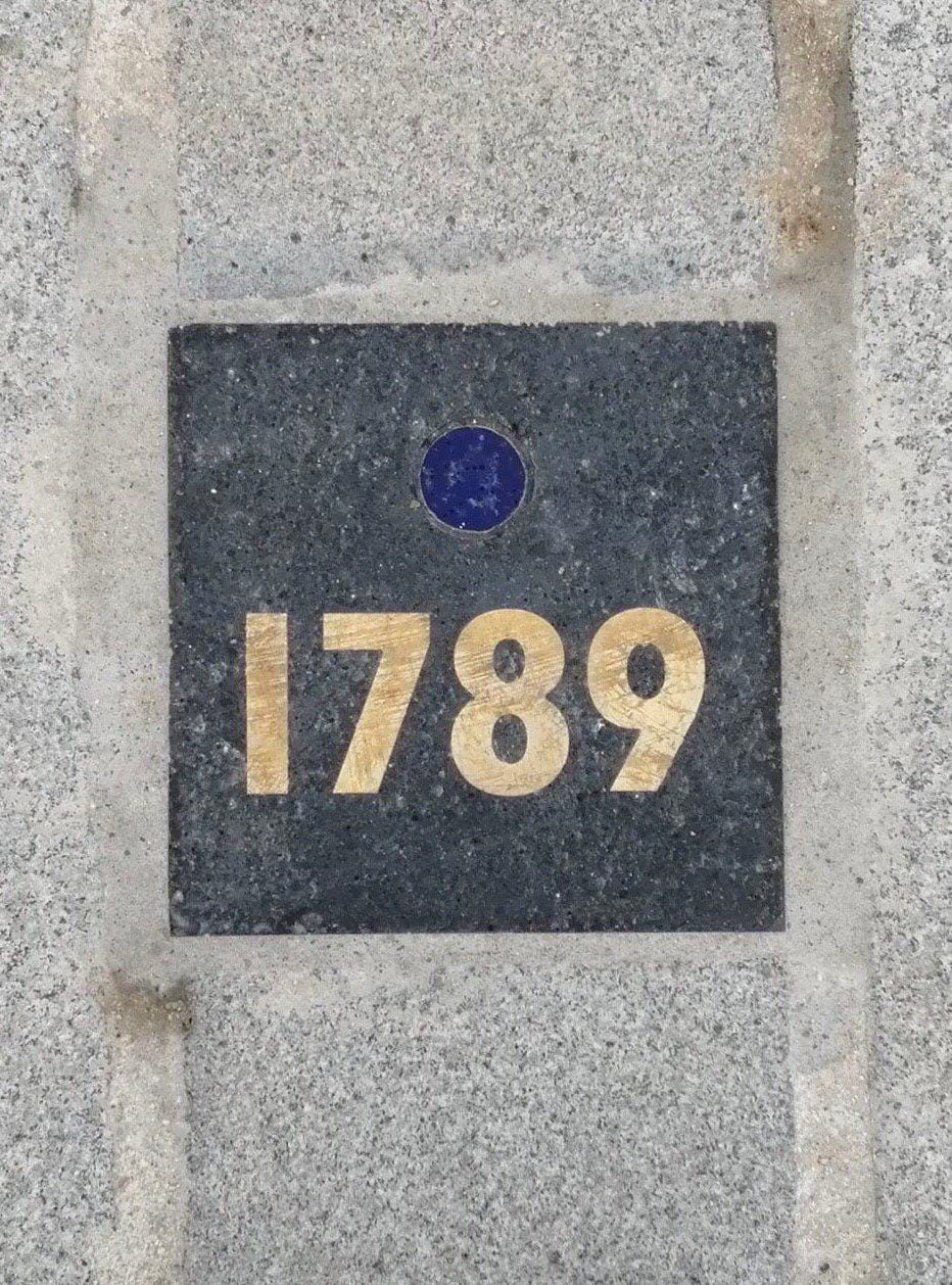 Commemorative tiles in the paving of Place de la Bastille in Paris and bronze plaques in Moscow's Prechistenka