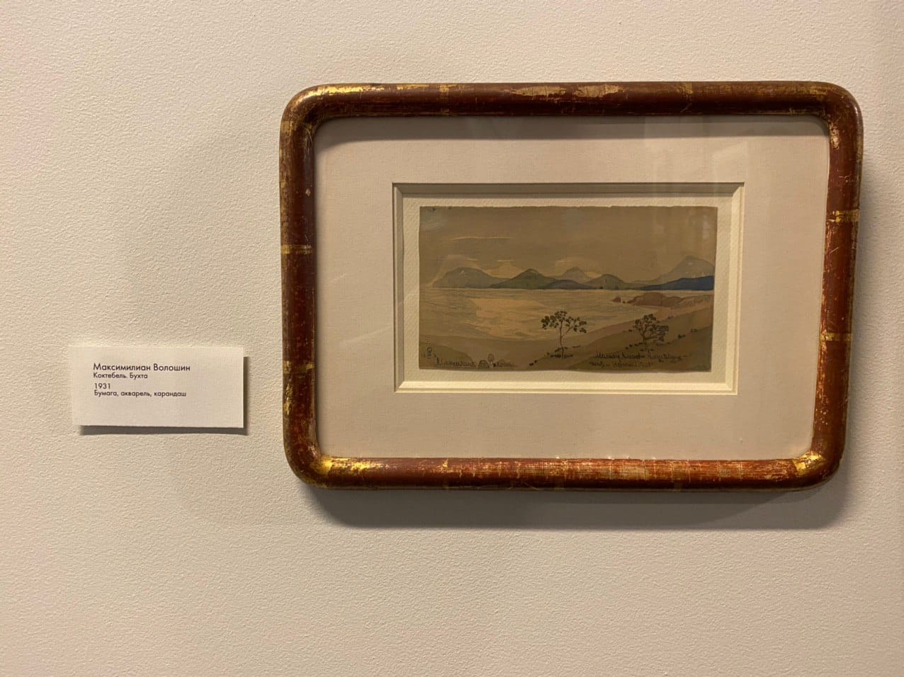 Petite aquarelle d'une baie et de montagnes dans un cadre à patine dorée ; le cartel indique Maximilian Volochine, Koktebel. La baie, 1931, papier, aquarelle, crayon.