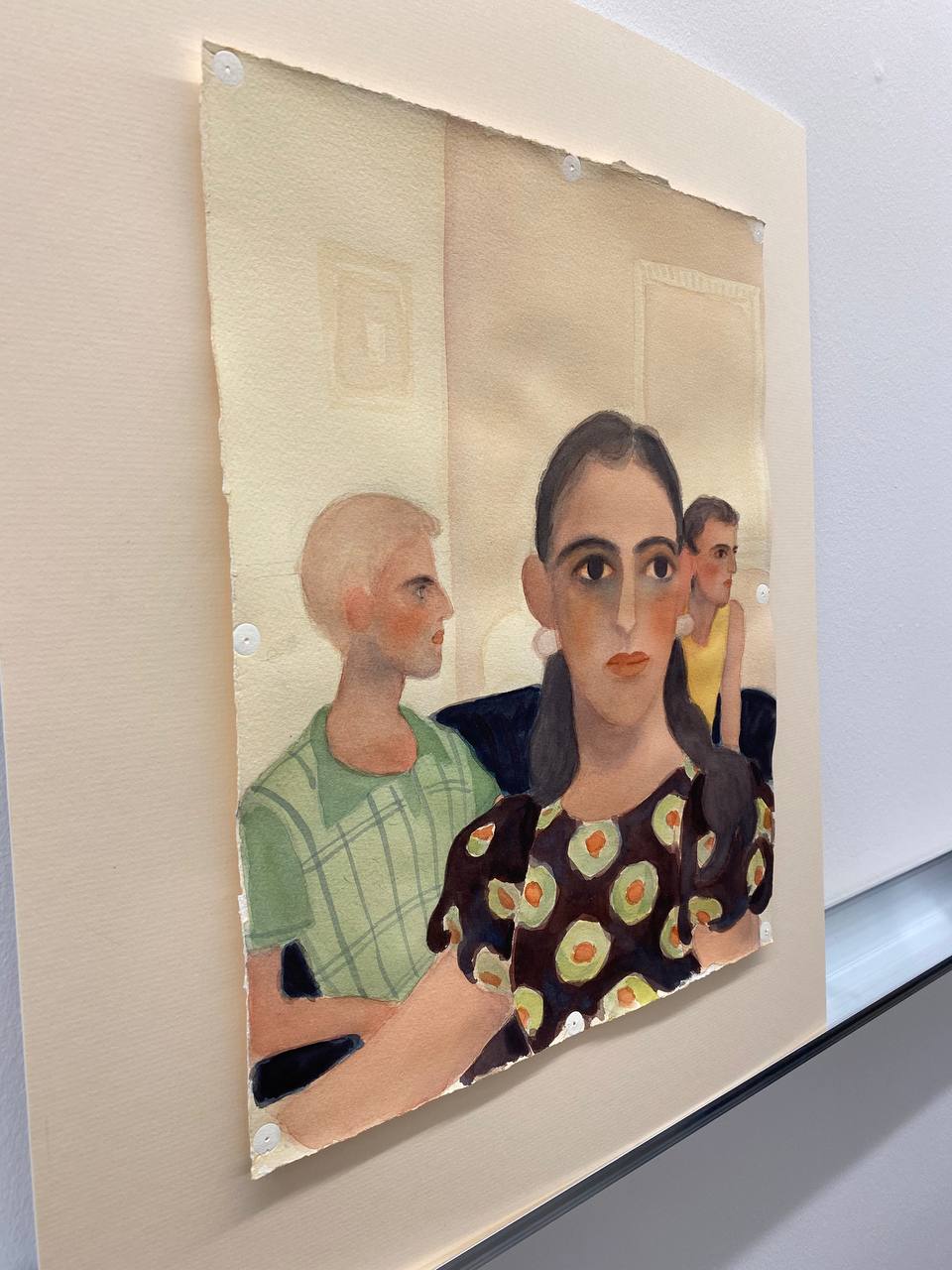 Aquarelle sur feuille à bords irréguliers fixée sur un passe-partout : une femme brune en robe à motifs vert et orange, et derrière elle deux personnes de profil, en vert et en jaune.