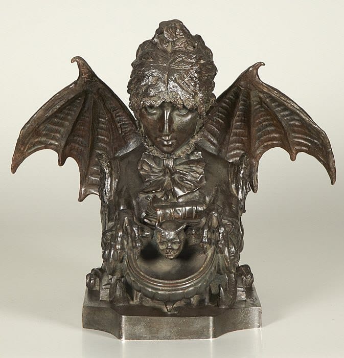 Bronze inkwell shaped as a bust of a woman with bat wings, a bow at the neck and a small chimera face on the basin.