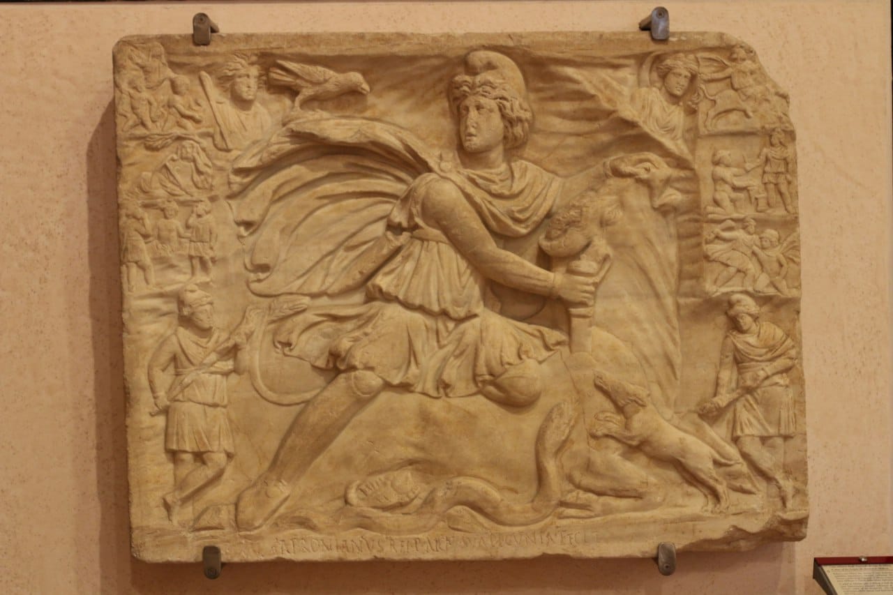 Roman marble relief of Mithras slaying the bull, with a snake, a dog and a scorpion, small scenes along the edges and an inscription below.