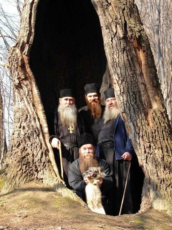 Des popes et un chien dans la chapelle aménagée dans le tronc d'un vieux chêne, monastère-ermitage Saint-Nicolas, district de Koropa, région de Tchernihiv, Ukraine