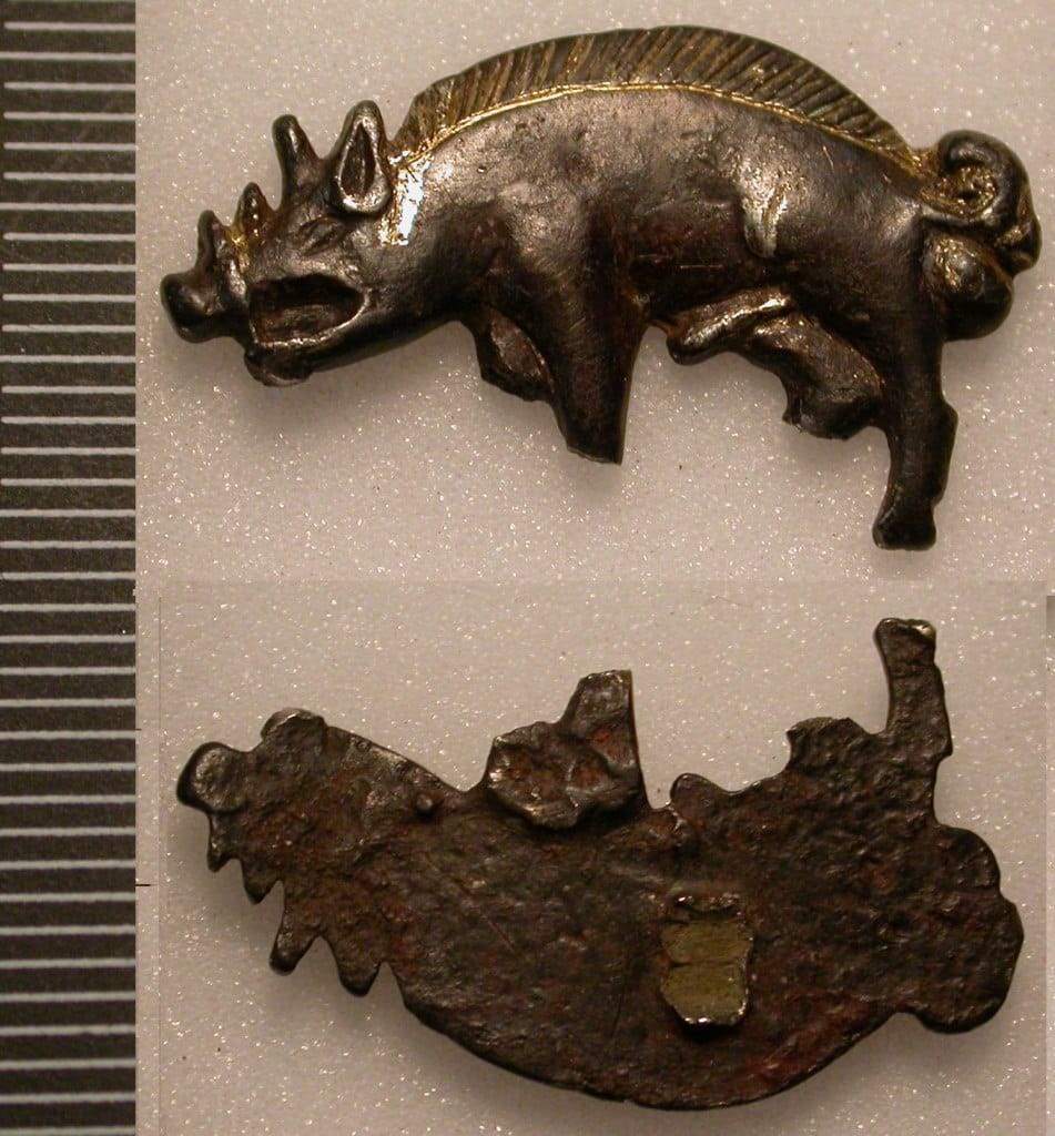 Silver badge in the shape of a boar with a gilded bristled back, shown from the front and the reverse, beside a scale ruler.