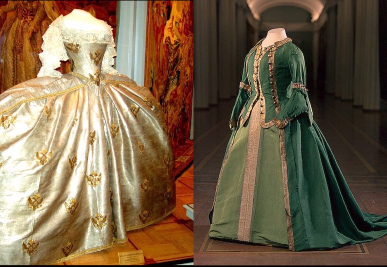 Two museum mannequins: on the left a white coronation gown with gold eagles and lace, on the right a green uniform dress with braid.