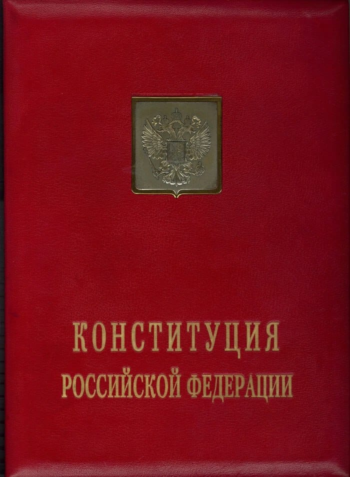 Красная кожаная папка с золотым гербом России и надписью «Конституция Российской Федерации».