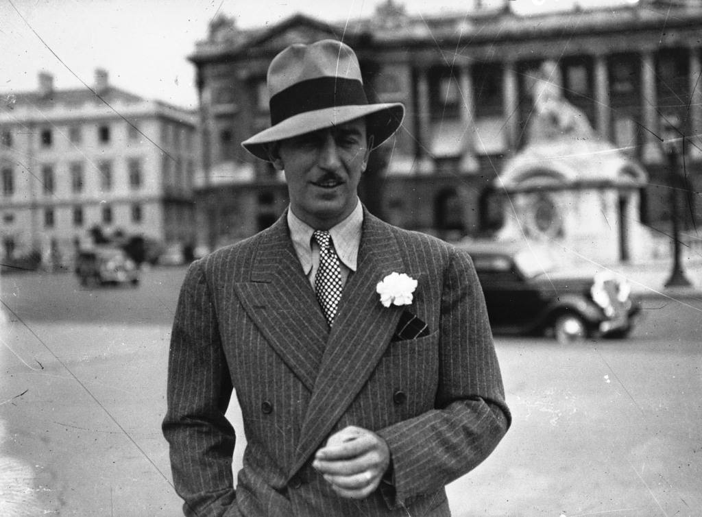 Уолт Дисней в Париже на площади Согласия в 1935 году напоминает о французском происхождении своей фамилии, изначально звучавшей как d'Isigny