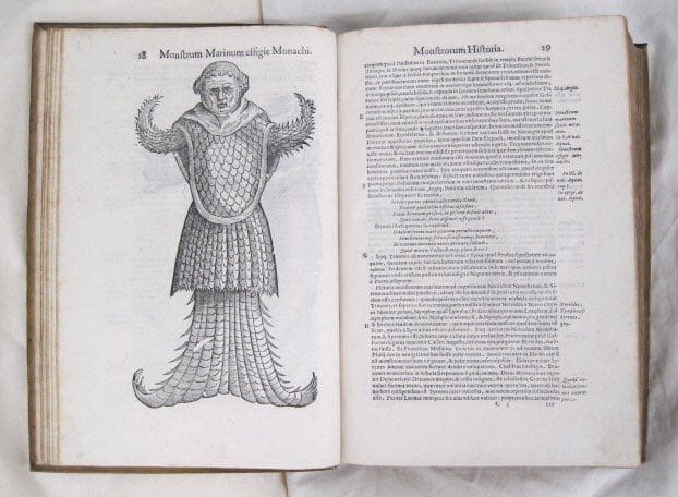 Раскрытая старинная книга с гравюрой морского монаха, существа с чешуёй и рыбьим хвостом, и латинским текстом на соседней странице.