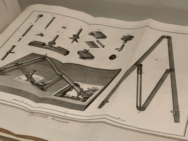 Раскрытая книга с гравированной таблицей: пантограф в работе, его рычаги и отдельные детали, внизу подпись «Dessein, Pantographe» и масштабная линейка.