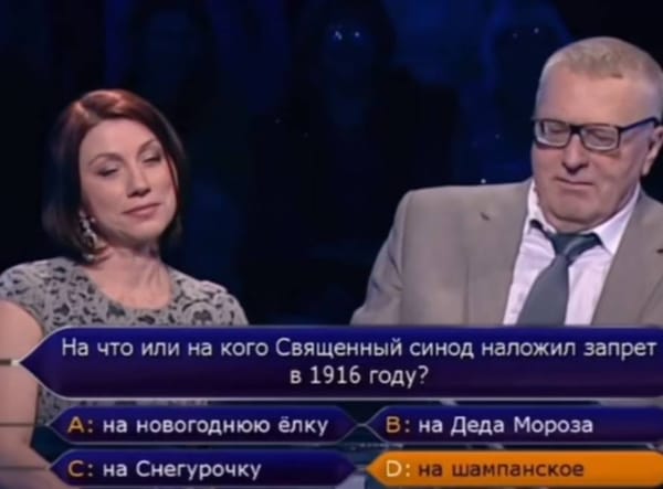 Кадр телевикторины: женщина и мужчина в очках, внизу вопрос о запрете Священного синода в 1916 году и четыре варианта ответа.