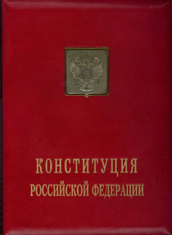 Красная кожаная папка с золотым гербом России и надписью «Конституция Российской Федерации».