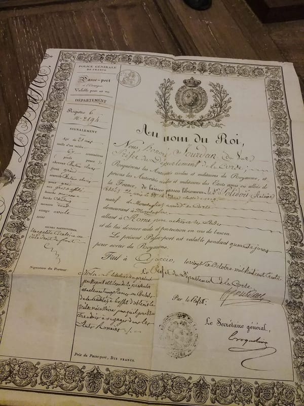 Лист французского паспорта 1830 года с орнаментальной рамкой, гербом, рукописным текстом и печатями на деревянном столе.
